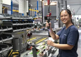 Une opératrice effectuent le montage d'un produit Socomec