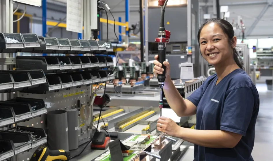 Une opératrice effectuent le montage d'un produit Socomec